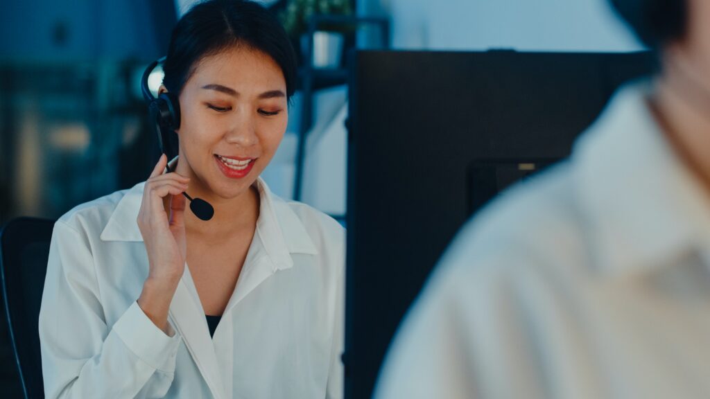 Asia young call center team using computer and microphone headset working.